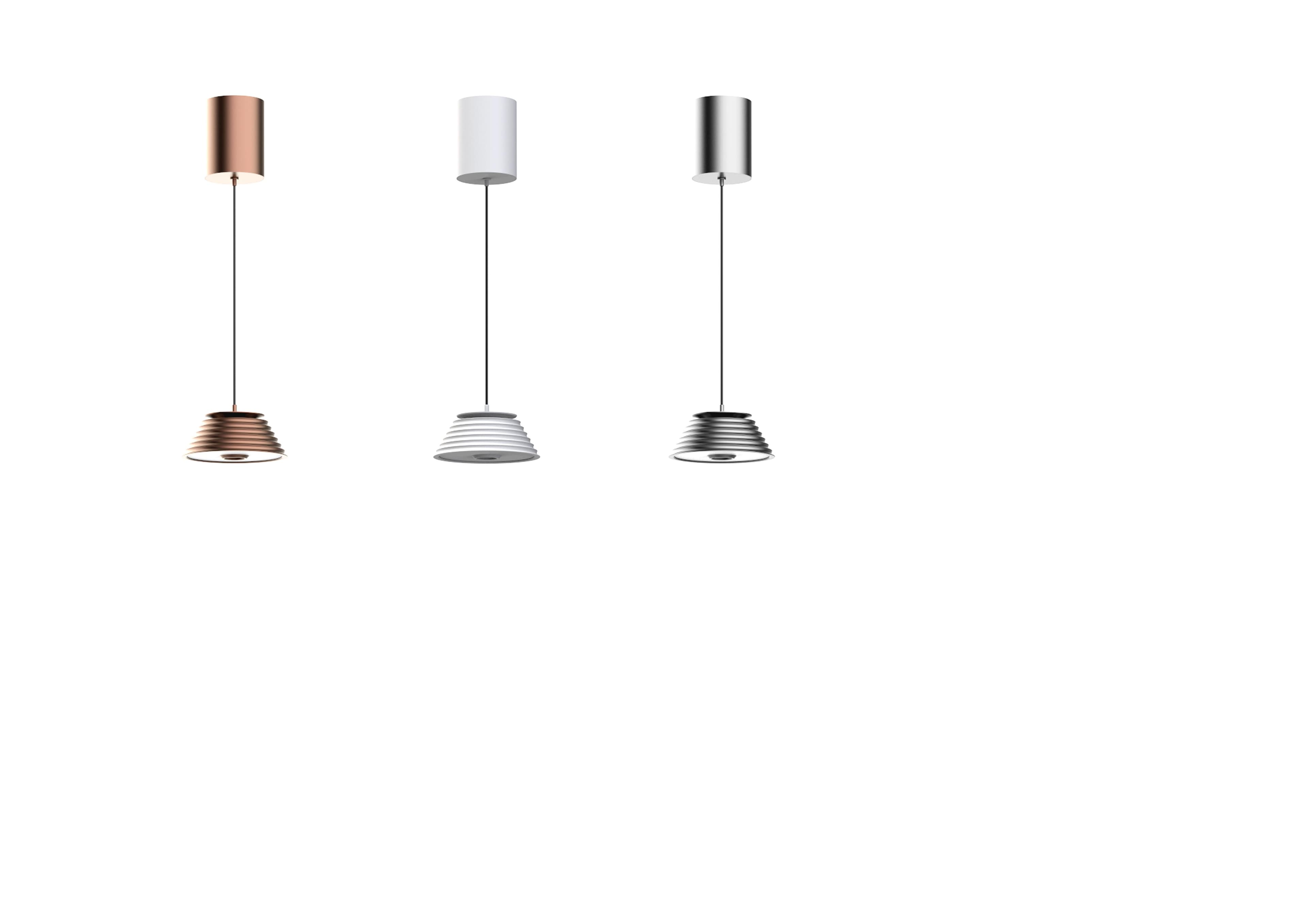 Three pendant lights with cylindrical tops and ribbed, bell-shaped shades are shown in different metallic finishes: rose gold, white, and silver.