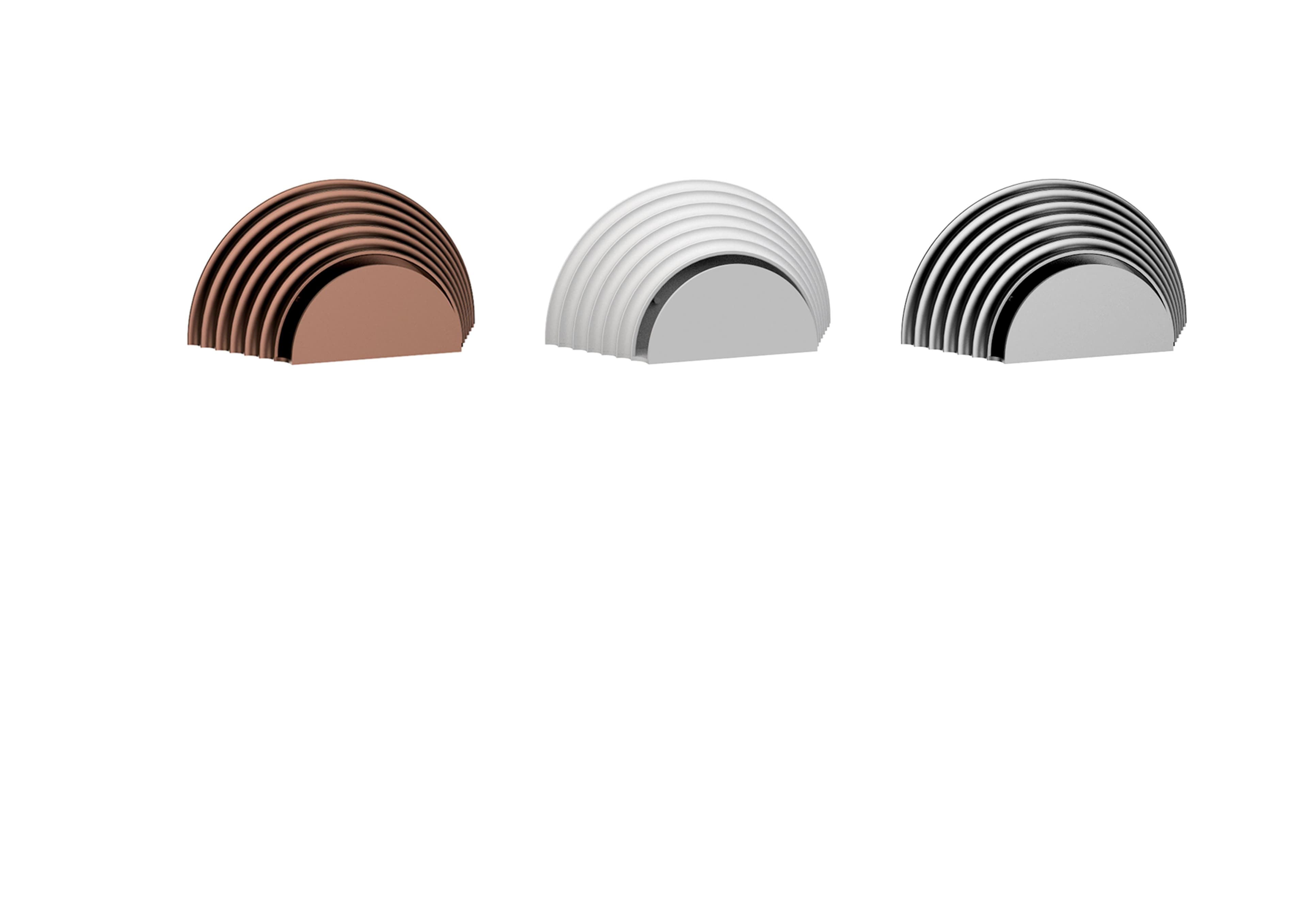 Three semi-circular, ribbed decorative elements in copper, white, and silver finishes are displayed against a white background.