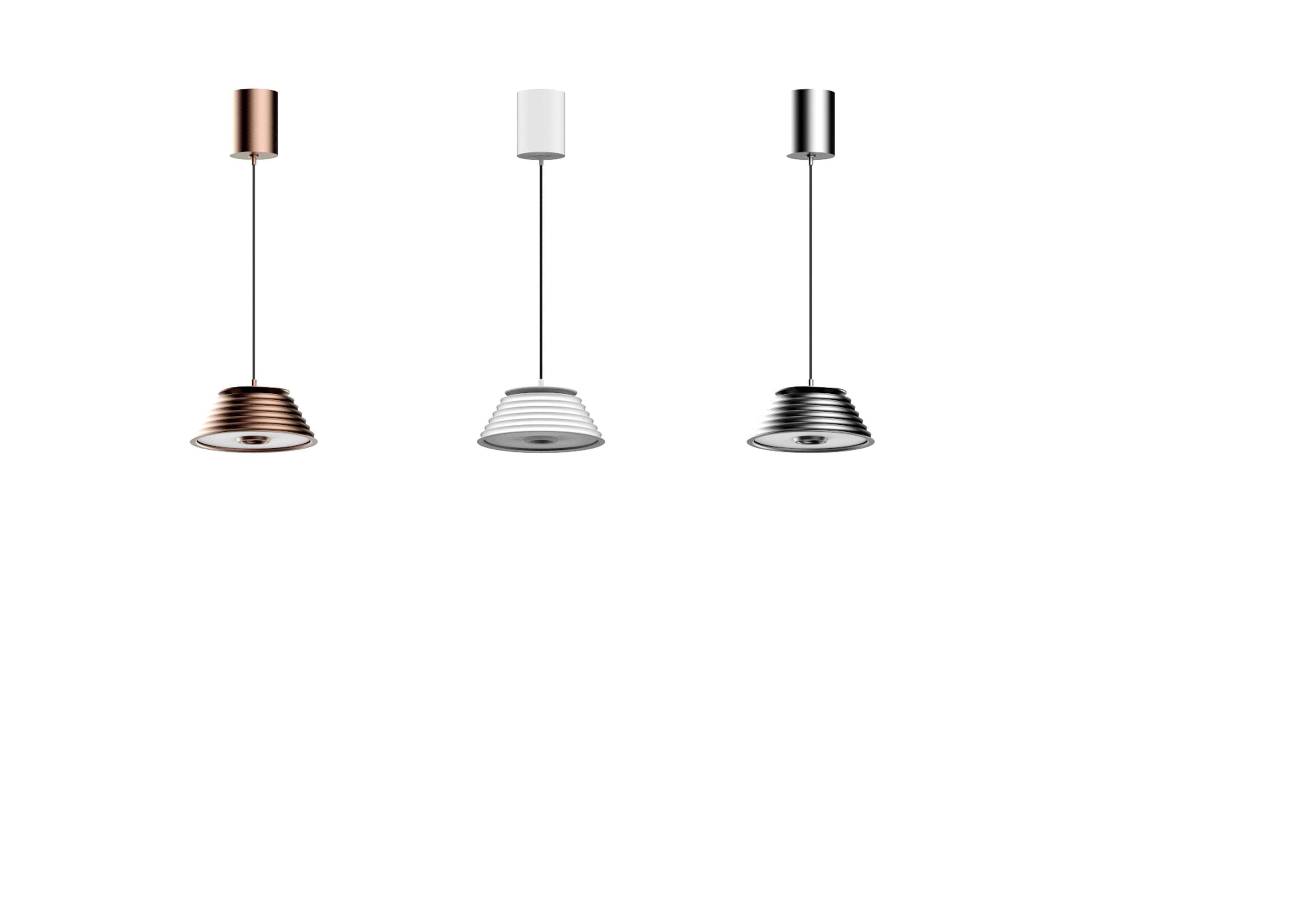 Three modern pendant lights with cylindrical tops and ribbed, bell-shaped shades are displayed against a white background, featuring finishes in rose gold, white, and silver.